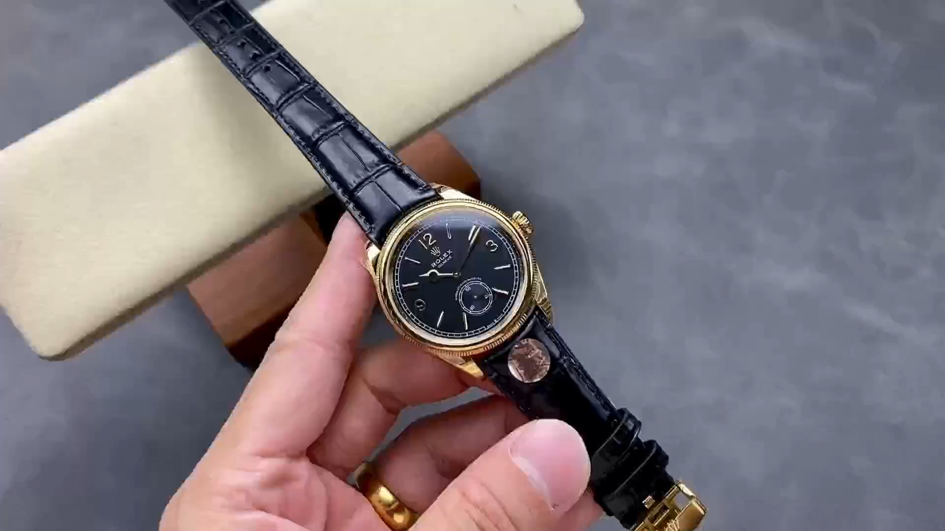 Video of Rolex 1908 Yellow Gold 52508-0002 replica showing black leather strap and gold buckle in hand.