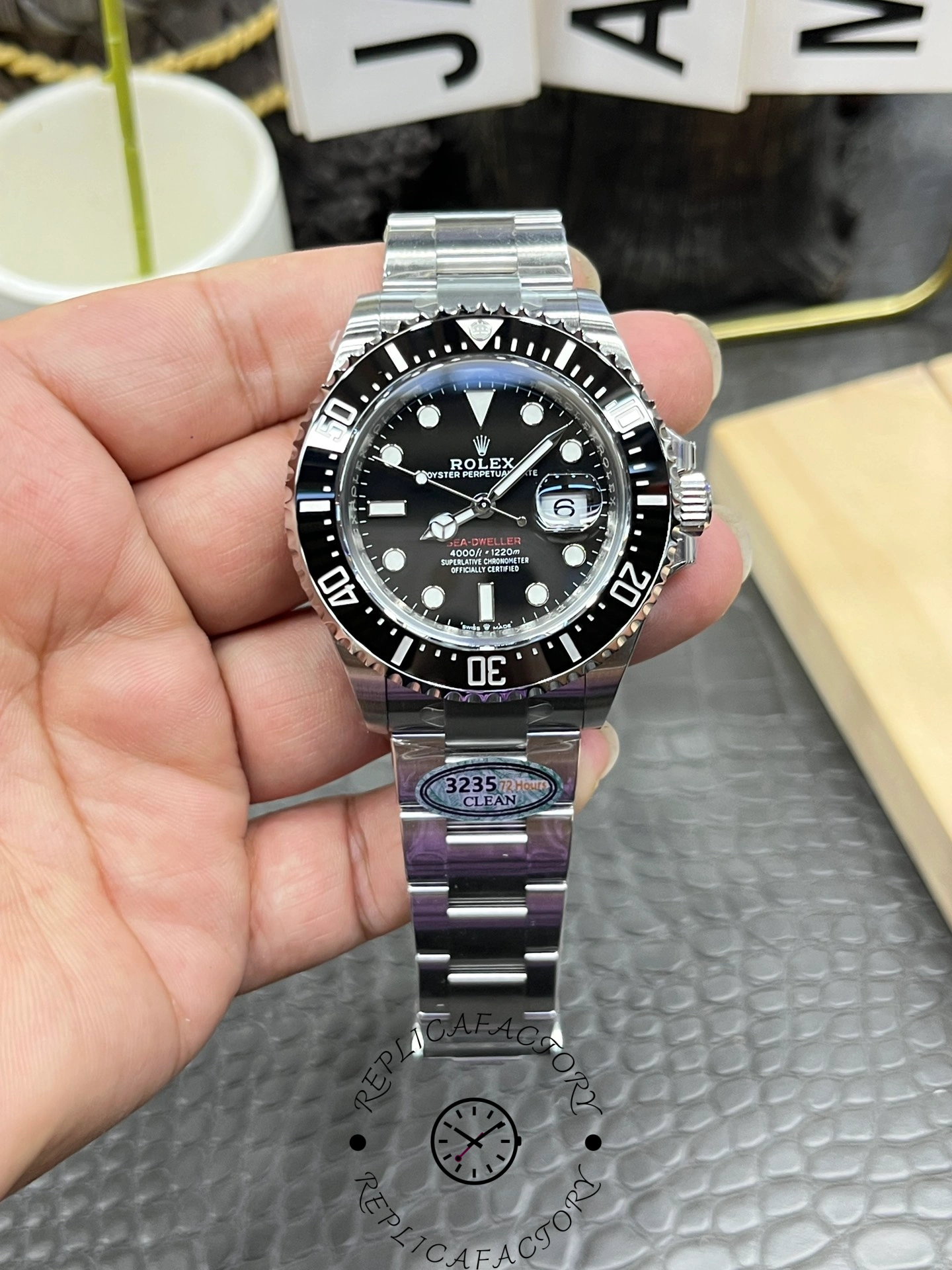 Rolex Sea-Dweller 126600 0002 held in hand, black dial and bezel, Oyster bracelet, front view.