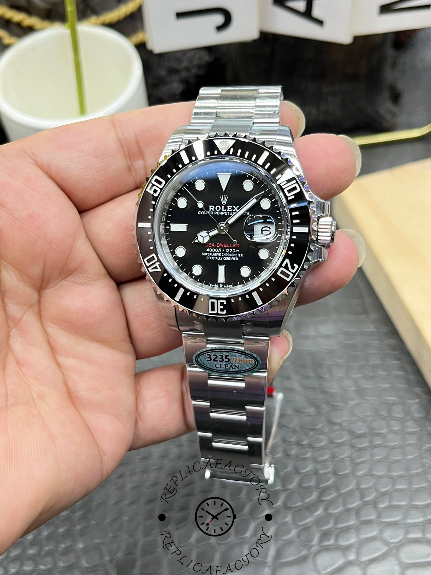 Rolex Sea-Dweller 126600 0002 angled view, black dial and bezel, Oyster bracelet, in hand.